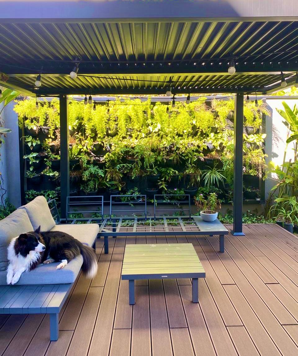Área residencial com jardim vertical, pergolado e deck